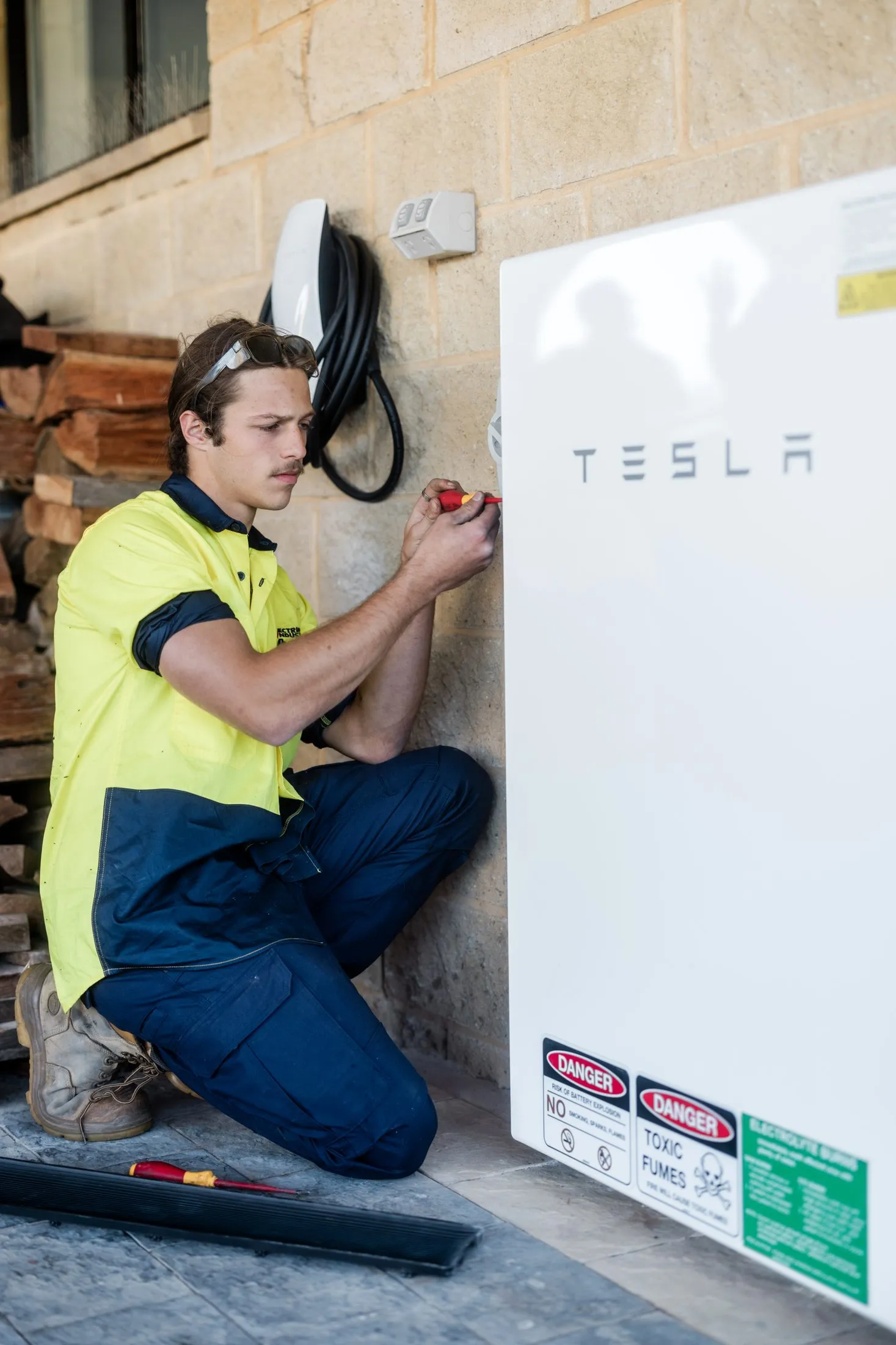 An installer connecting a home battery to store surplus daytime solar