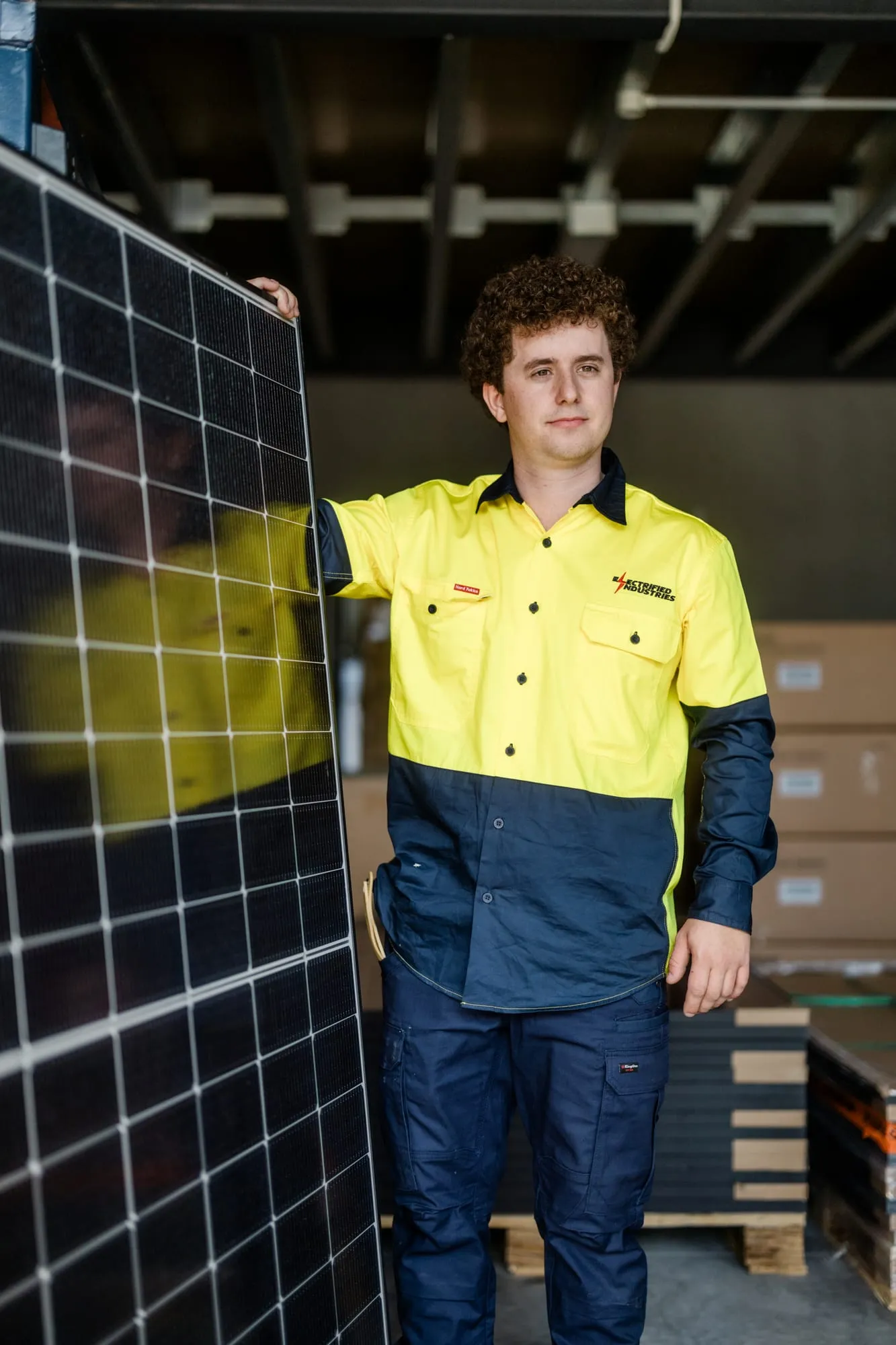An Electrified Industries installer with a solar panel, ready for a Lake Macquarie install