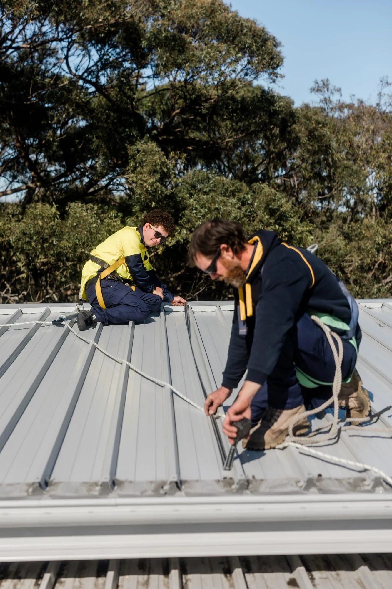 Electrified Industries installers wiring a rooftop solar array