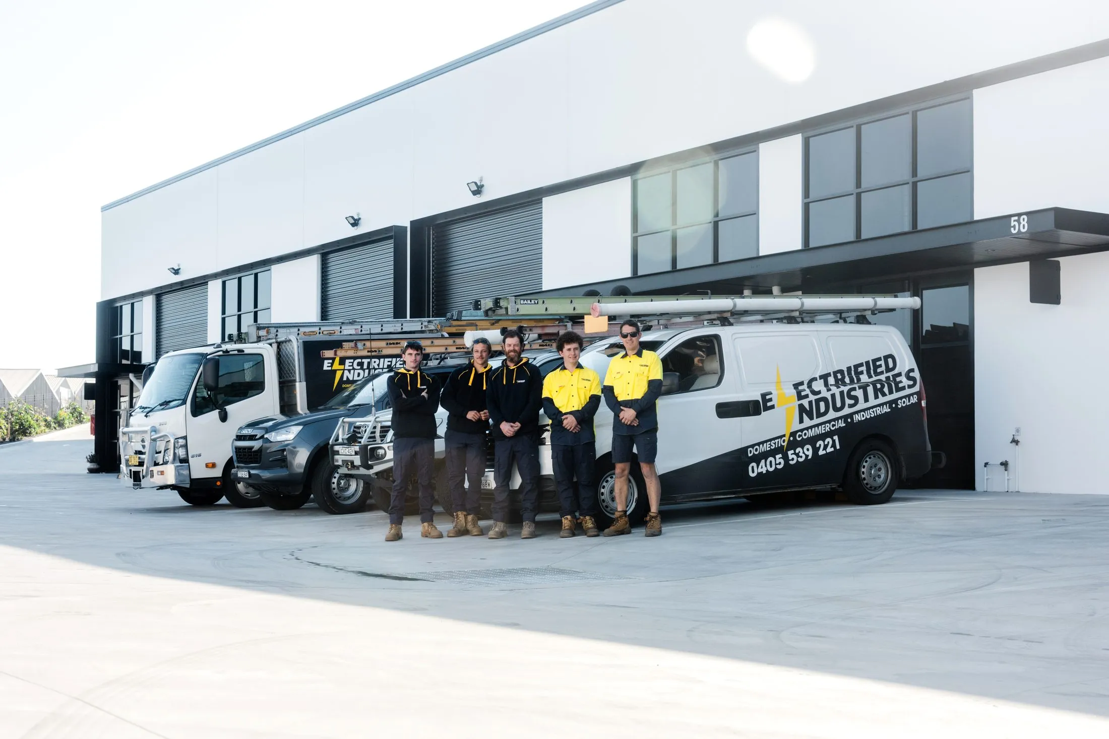 The Electrified Industries team in front of their branded vans