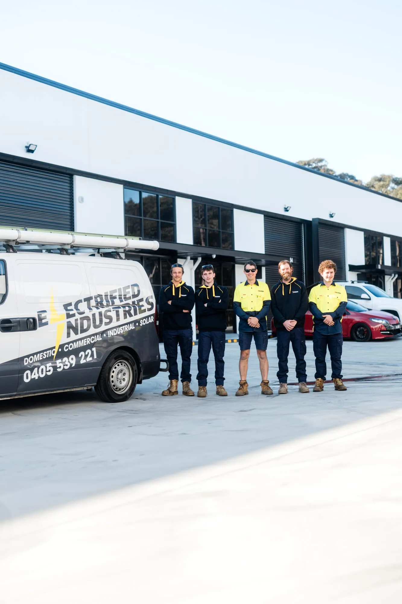 The Electrified Industries crew lined up with a work van, ready for jobs across Newcastle